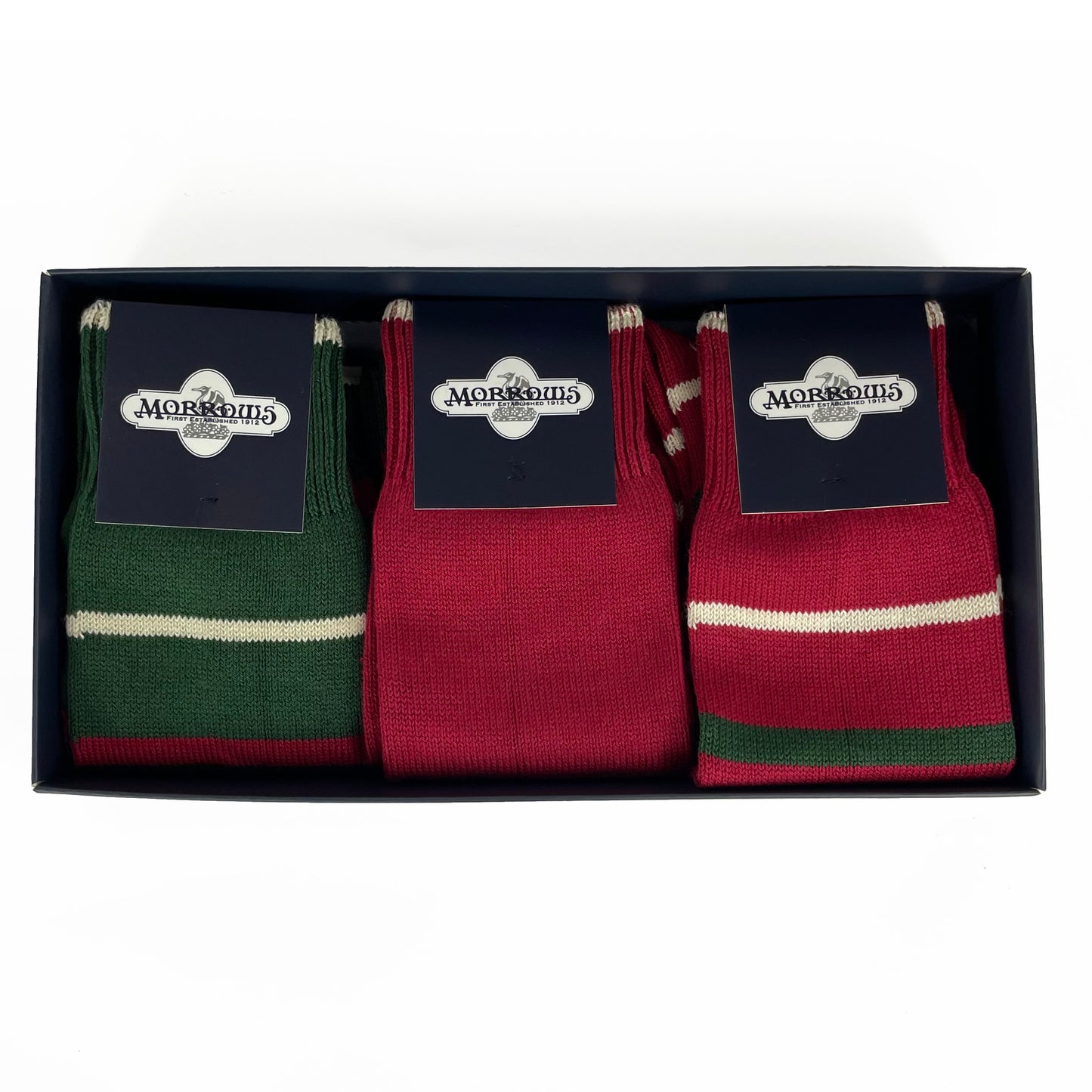 box of three socks. Left to right: green with thin cream and red stripes; red with cream detail; red with thin cream and green stripes